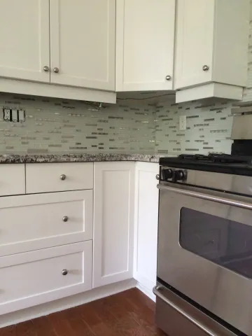 Kitchen corner with mosaic tile and a speckled stone countertop