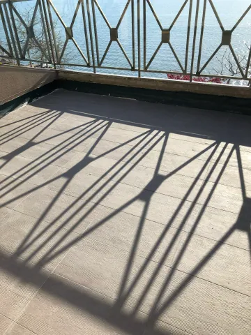 Balcony tiles and shadows from the metal railing