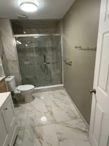 Glass shower enclosure and white bathroom vanity