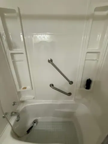 White shower surround with chrome grab bars