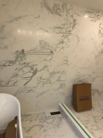 Large marble-look tiles and recessed niche in a shower