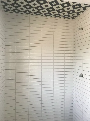 White subway tiles with a contrasting patterned shower floor