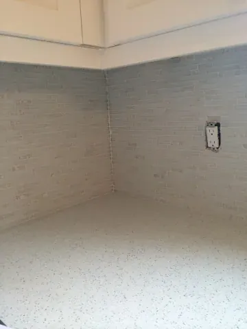 Light kitchen backsplash beneath white wall cabinetry
