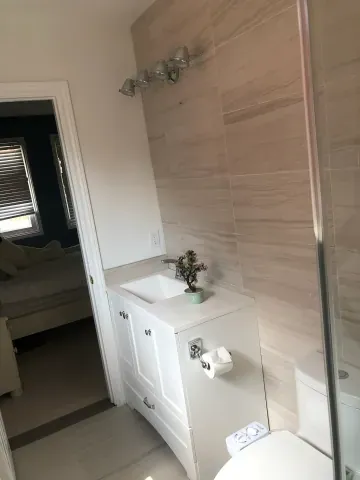 White bathroom vanity beside a glass shower enclosure