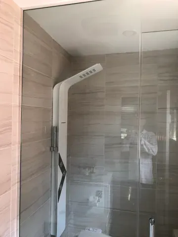 Glass shower enclosure with neutral horizontal wall tiles