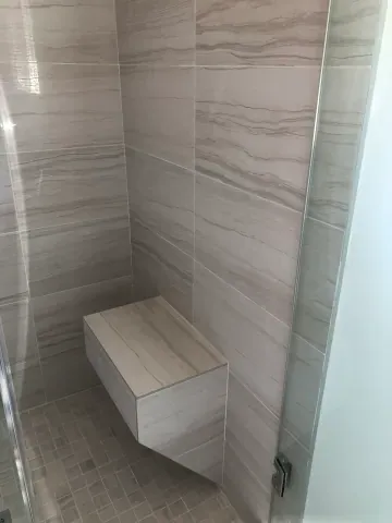 Tiled shower bench with horizontal stone-look tiles