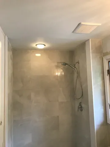 Stone-look tiled shower with recessed lighting