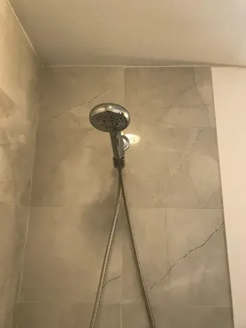 Shower head and textured wall tiles