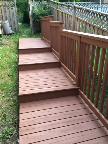 Timber steps and railing beside a finished outdoor walkway