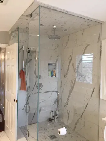 Glass shower enclosure and large veined wall tiles