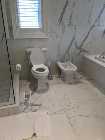 Marble-look bathroom floor and wall tiles beside the window