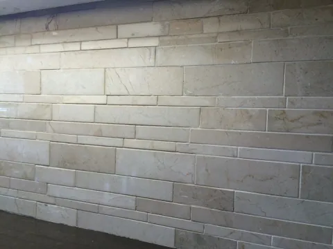 Stone kitchen backsplash and dark countertop under cabinet lighting